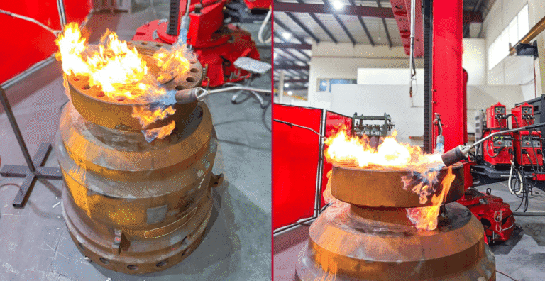 Gas torch preheating a thick steel flange before welding in a fabrication workshop
